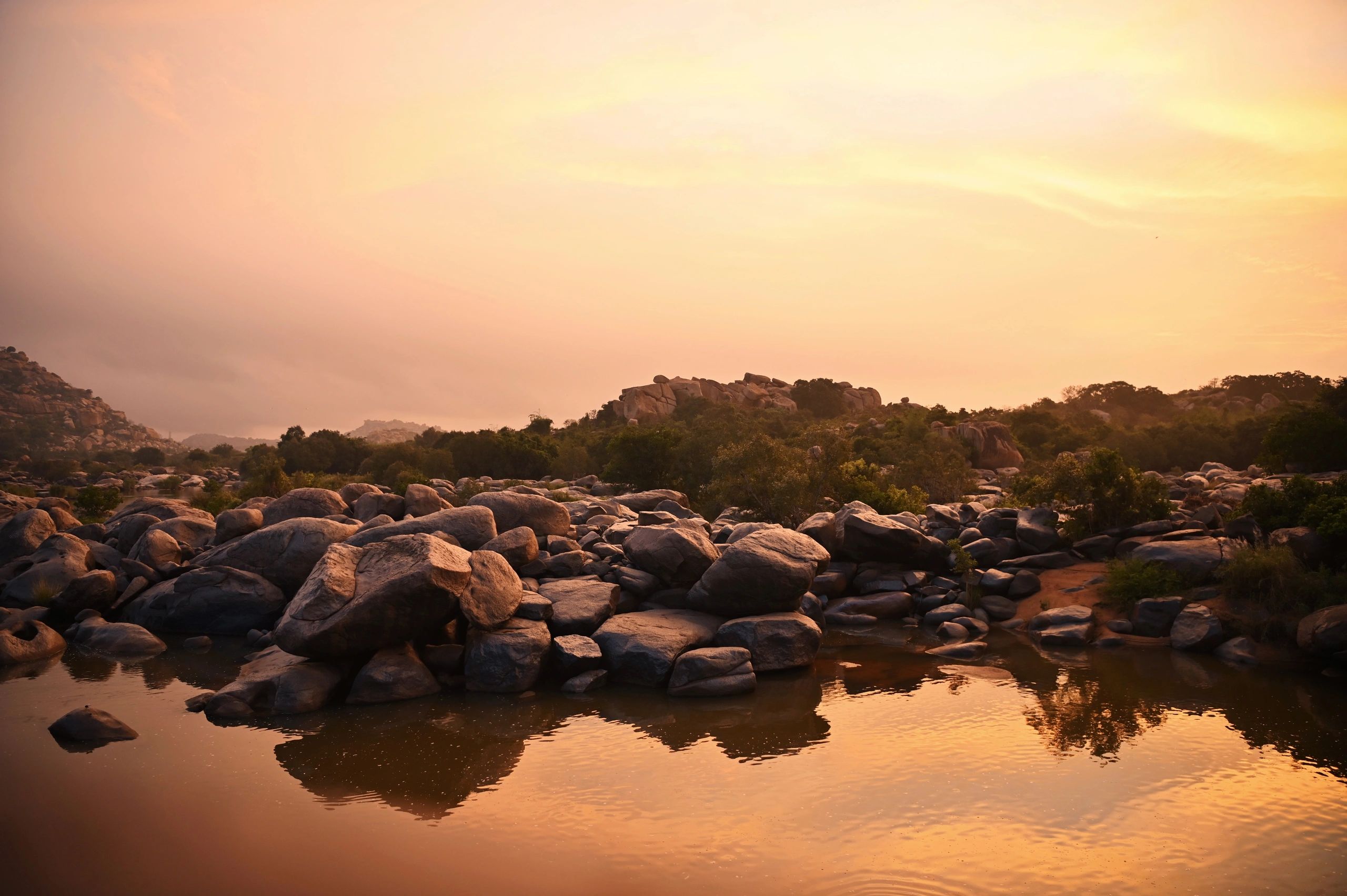 Sunrise over the river and granite boulders at Hampi, Karnataka