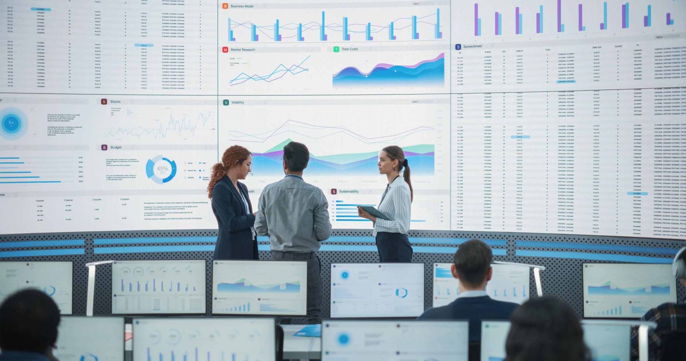 Team reviewing data and content dashboards on large digital screens