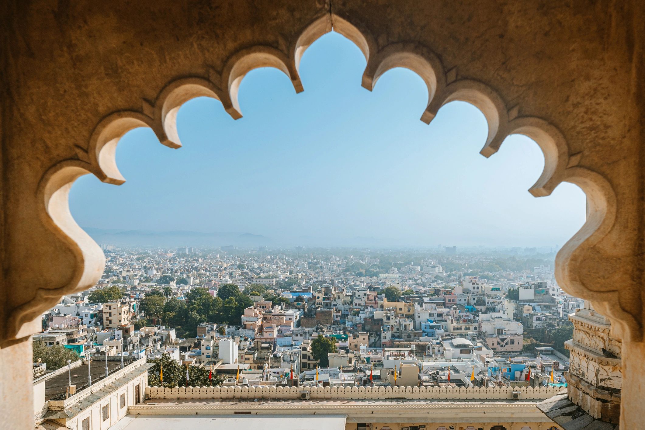 Udaipur city view framed by an ornate palace window